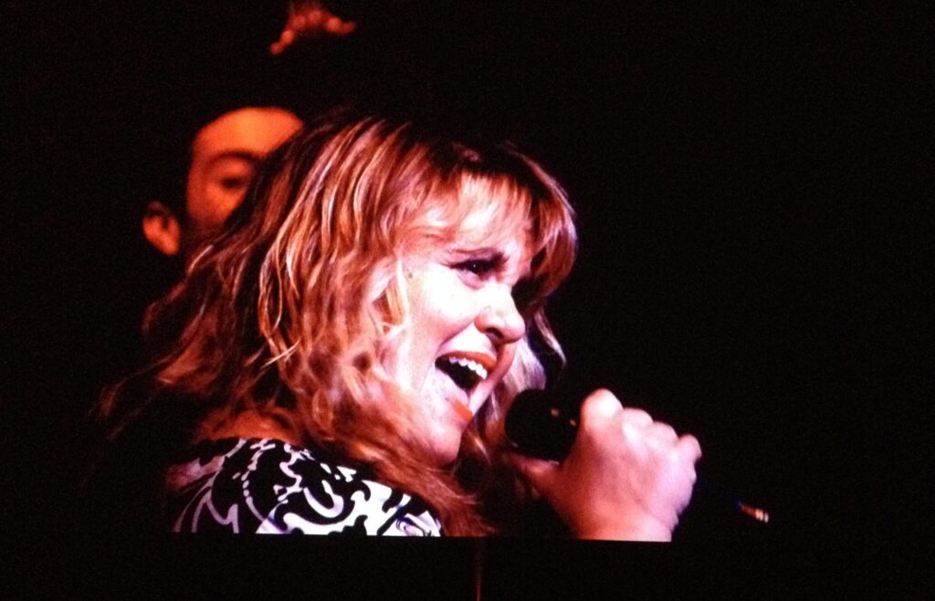 Denise Martin performing live onstage at The Nash in Phoenix, AZ, singing into a microphone.